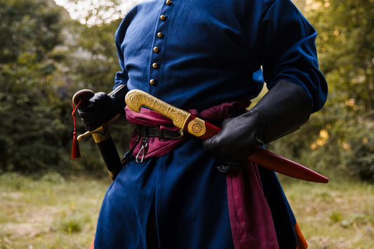 Khanjar dagger and leather sheath with brass hilt worn on a waist belt