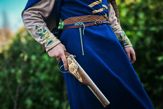 Wheellock blaster holster detail close-up with ornate brass trigger guard and leather belt medieval LARP
