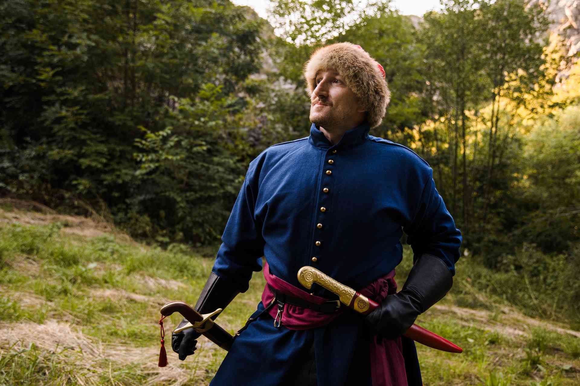 Khanjar dagger with brass hilt in a red leather sheath worn at the waist