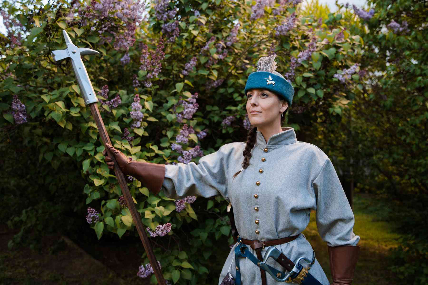 Woman medieval warrior in teal wool round cap with halberd polearm weapon