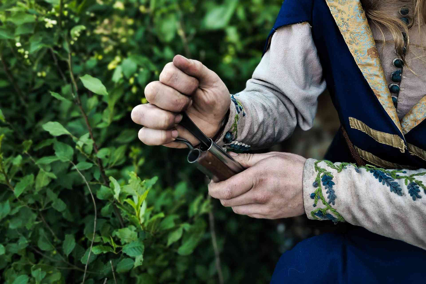 Close-up detail of loading wheellock blaster pistol with embroidered medieval sleeve LARP ammunition