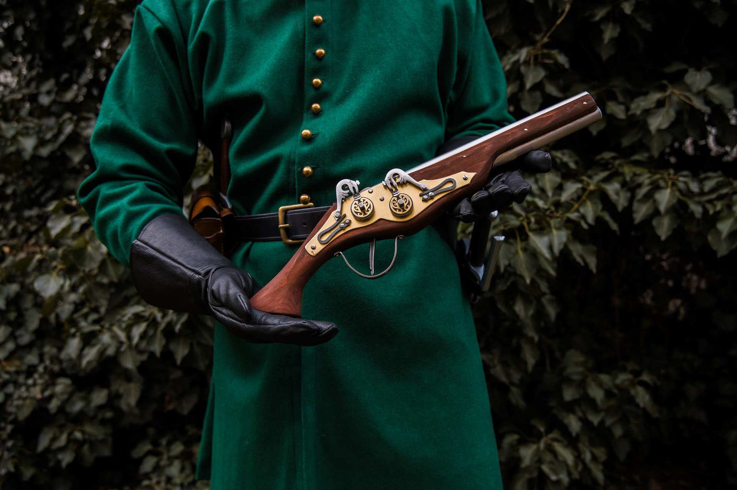 Medieval soldier in teal coat holding wheellock blaster LARP weapon