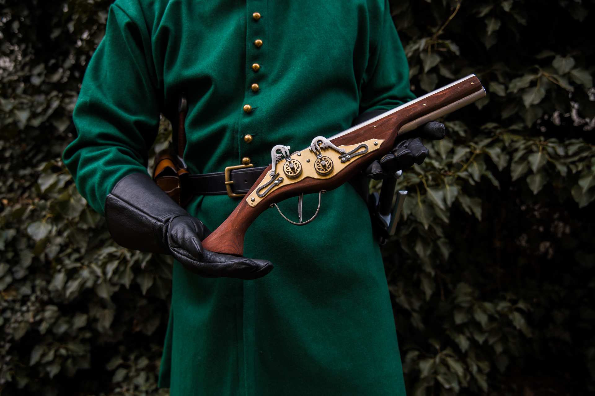 Medieval soldier in teal coat holding wheellock blaster LARP weapon