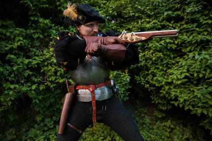 LARP soldier in shooting stance with ancient replica pistol and leather over-under holster medieval weapon