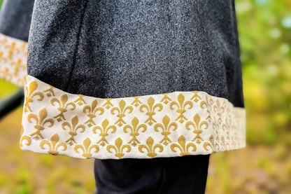 Close-up of coat hem with gold fleur-de-lis trim