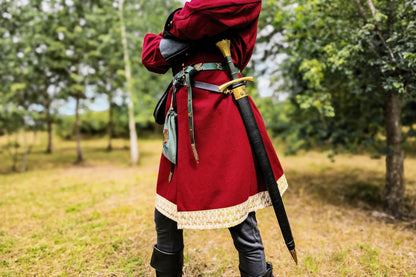 Red medieval coat with gold trim, back view with sword belt